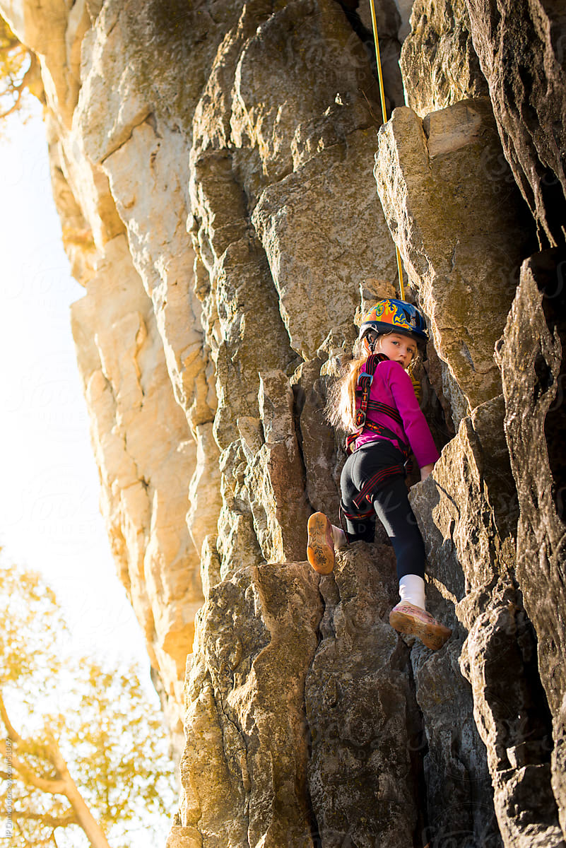 Little Girl Rock Climbing With Sun Flare