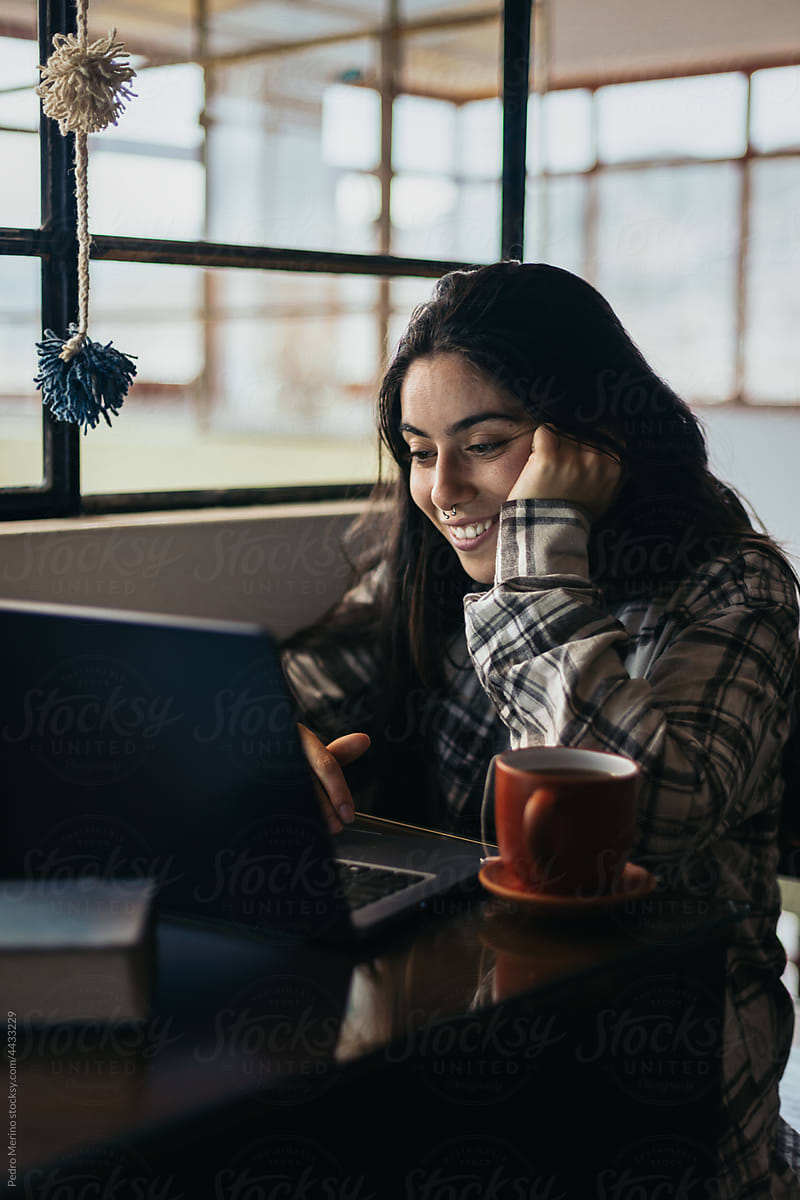 Young woman with laptop and a cup of tea