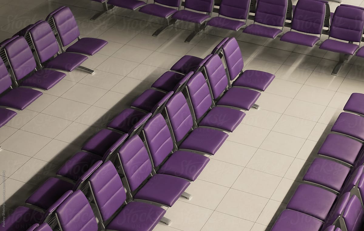 Line of purple chairs in row on waiting room on airport.