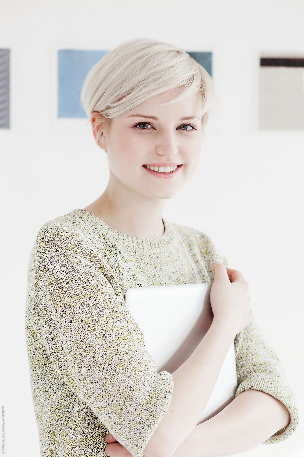 Portrait of a smiling young woman holding a tablet.