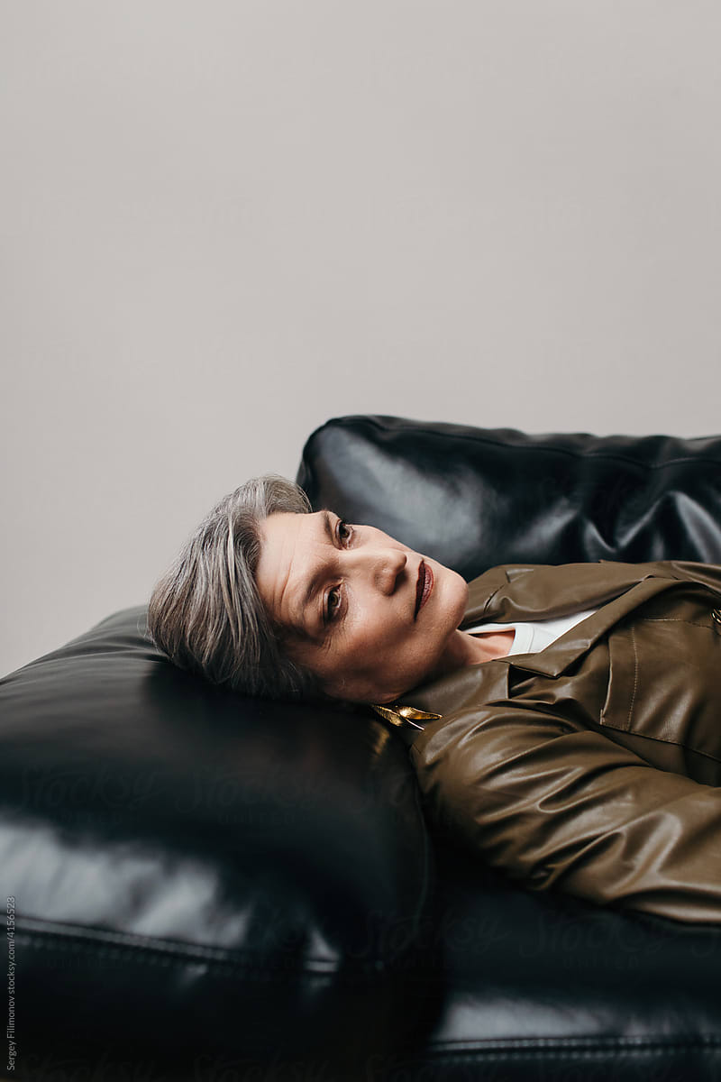 Lonely mature woman on leather sofa