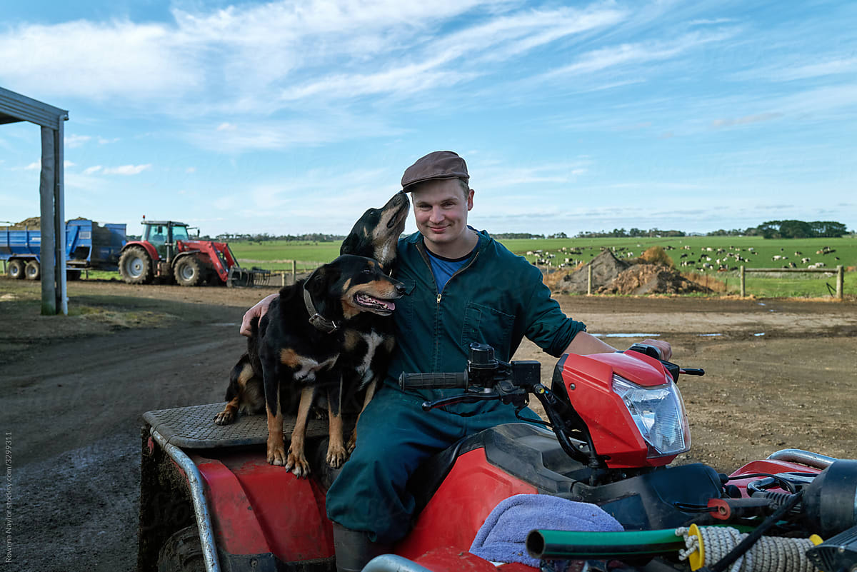 Dairy Farmer sitting on quad bike with farm dog