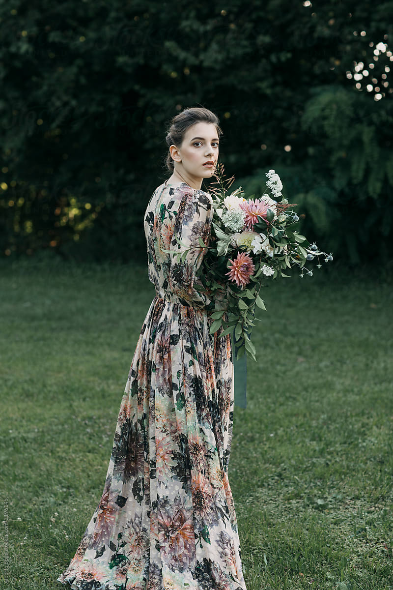 Woman in dress holding rustic bouquet