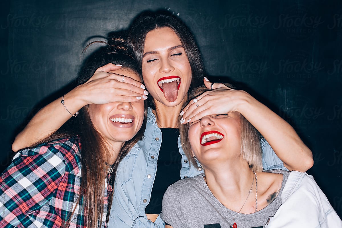 Closeup Funny Portrait Of Three Smiling Girls Showing Tongue By