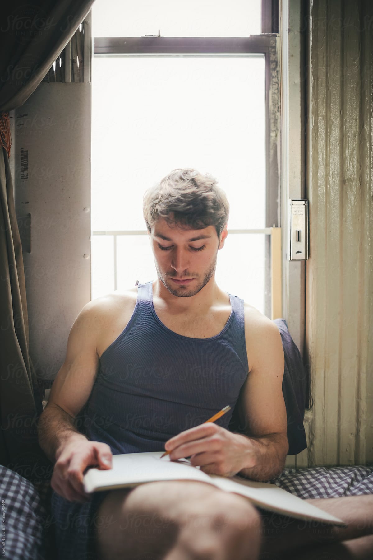 Man Writing and Sketching on Notebook in Bed at Home