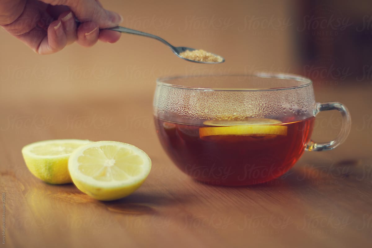 Hot tea in glass mug with lemon and sugar