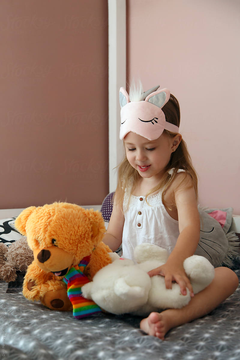 Girl playing with toys on bed