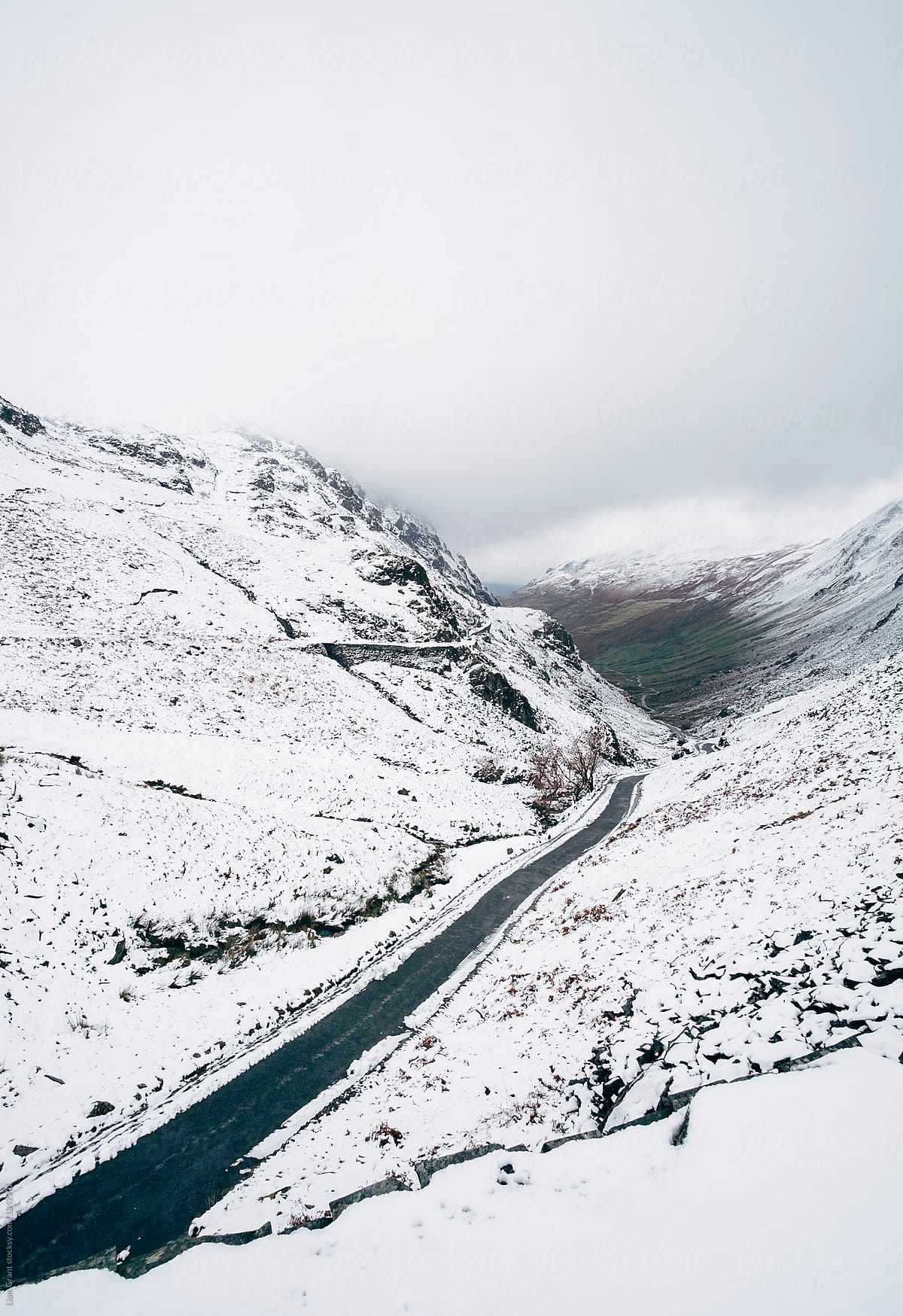 Road through a mountain pass in snow. Honister Pass, Cumbria, UK