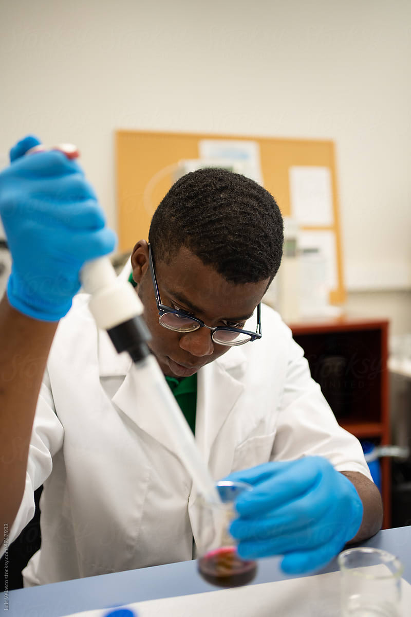 Black Scientist Focused Using The Pipette In The Lab.