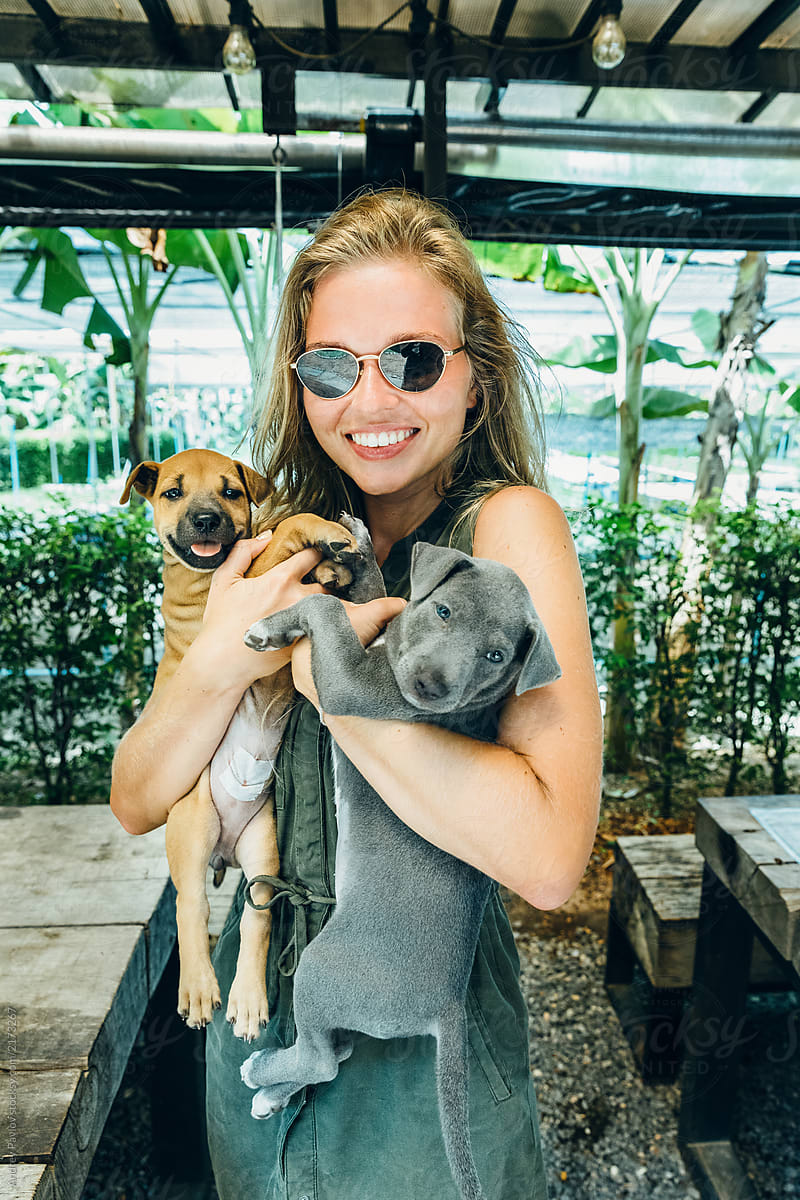 Woman hugging two cute puppies