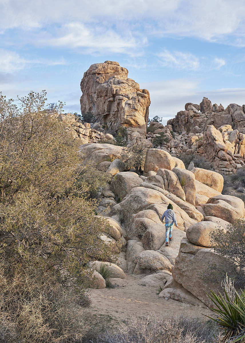 Little boy climbs a large rock formation in Joshua Tree National Park
