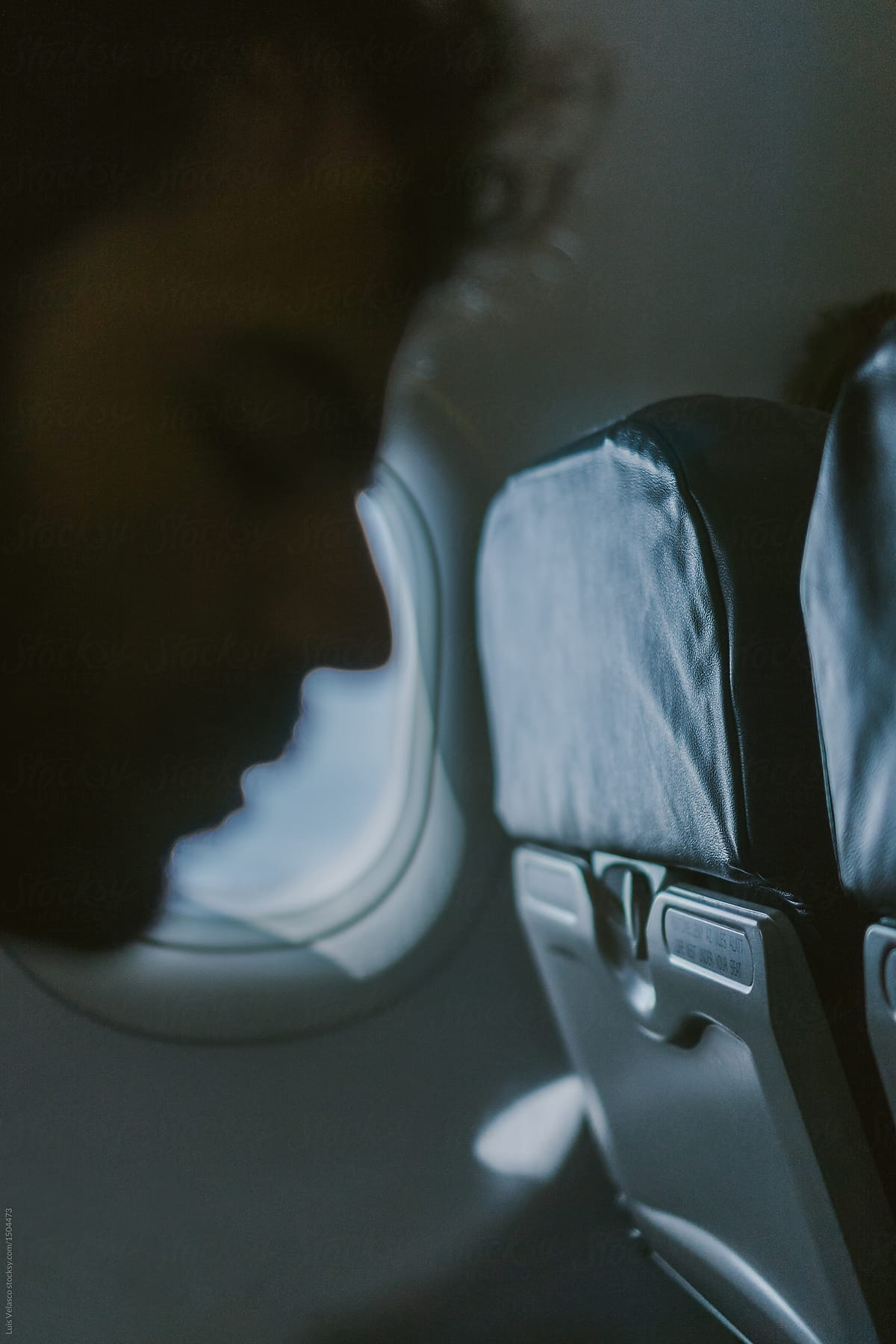 Silhouette of a Man Sitting in an Aircraft.
Looking Out from Airplane Window.
