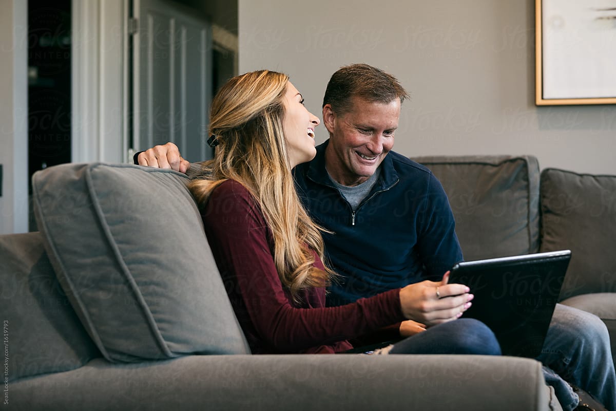 Home: Father And Daughter Laugh While Using Laptop