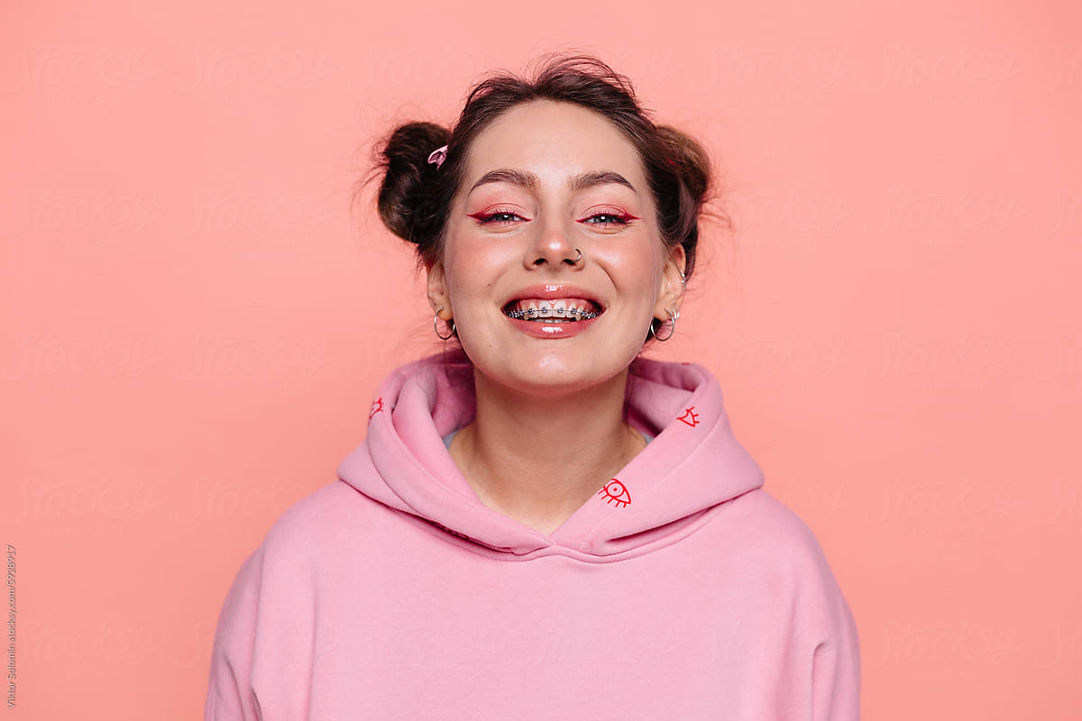 Smiling woman in hoodie looking at camera in studio