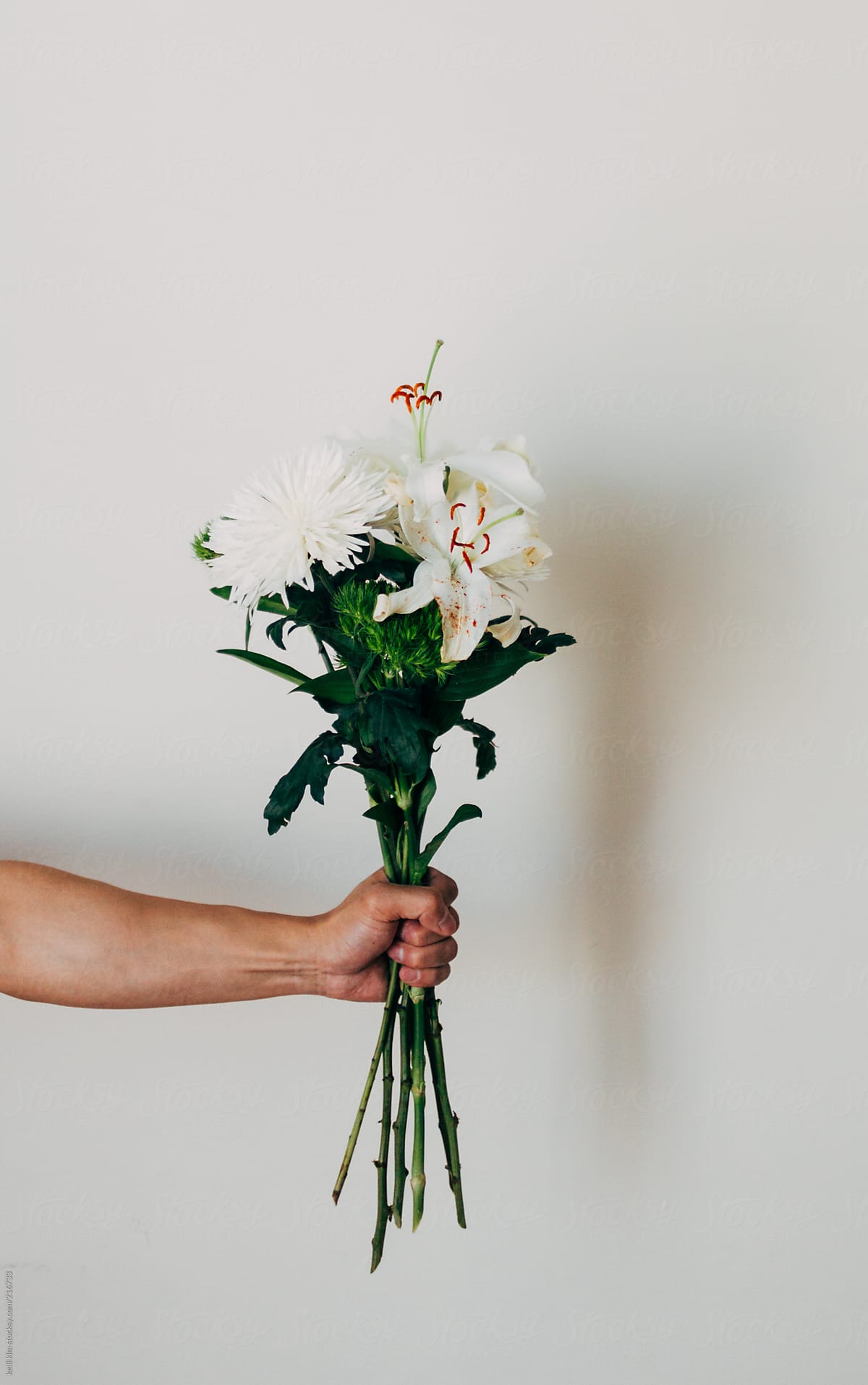 Hand holds bouquet of white flowers