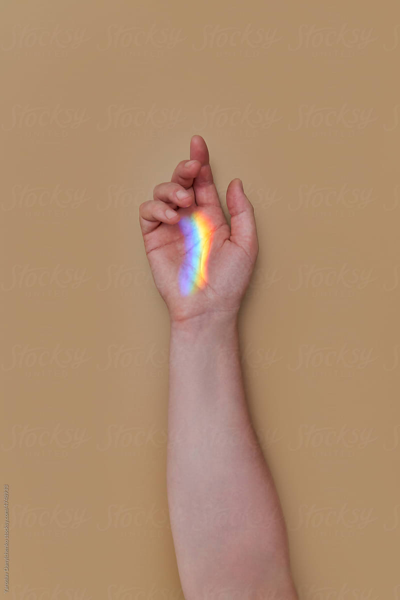 Person\'s arm with abstract rainbow.