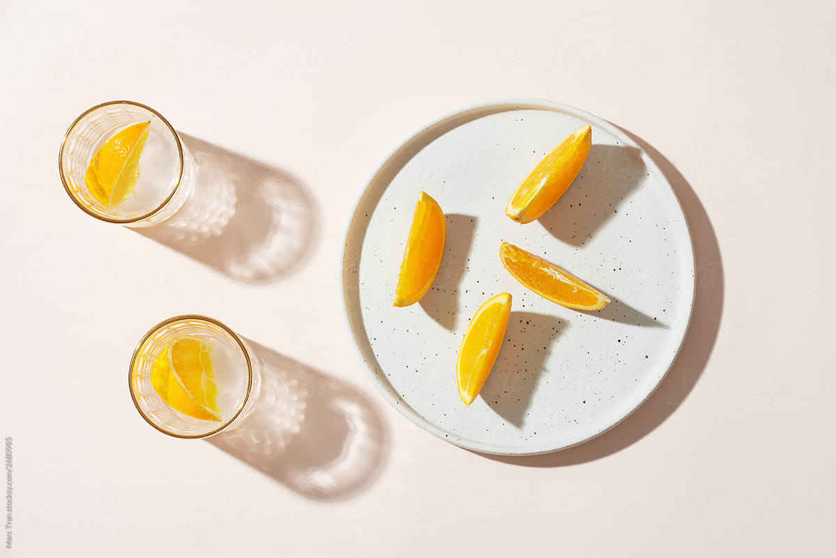 Water with orange with orange slices plate.