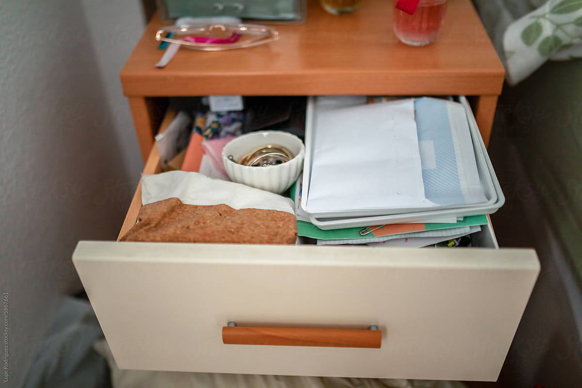 ugc of nightstand drawer open and full of things