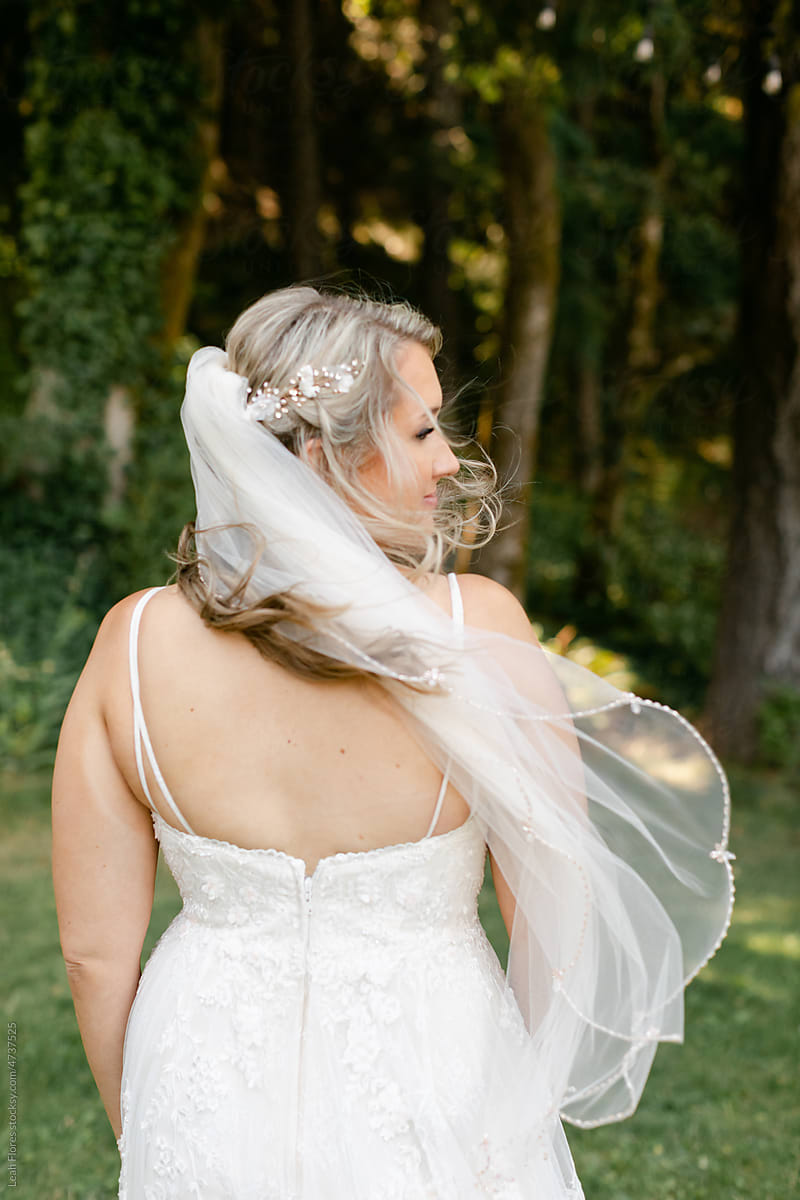 A Bride\'s Veil Blows in the Wind as She Stands in a Forest