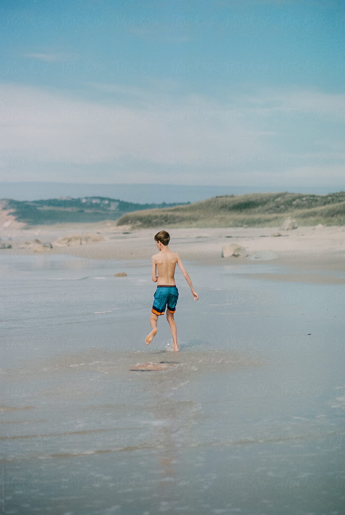 teen boy with skim board at the beach