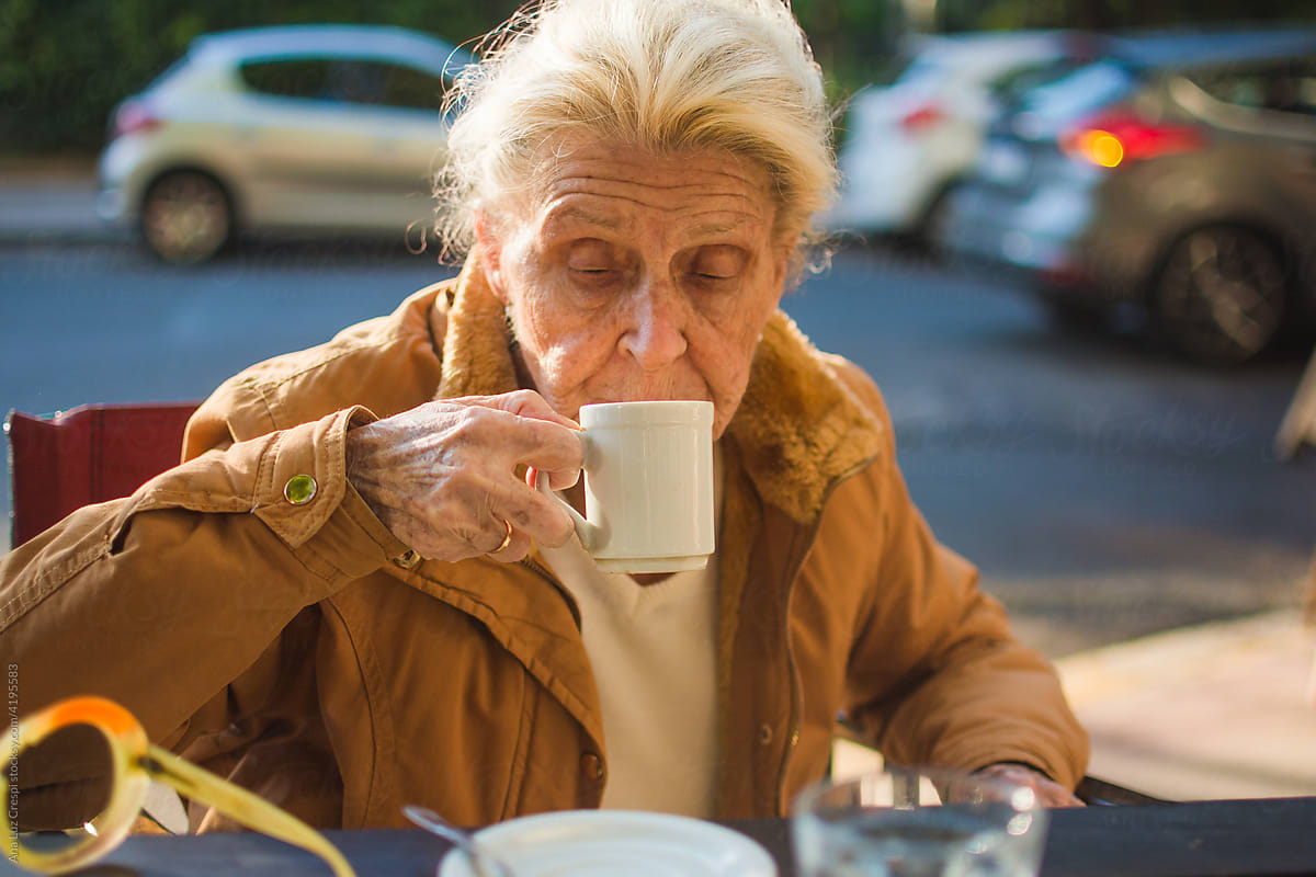Senior woman drinking coffee at outdoor cafe