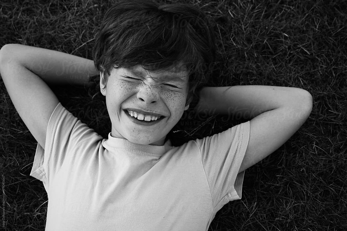 Happy boy resting on grass