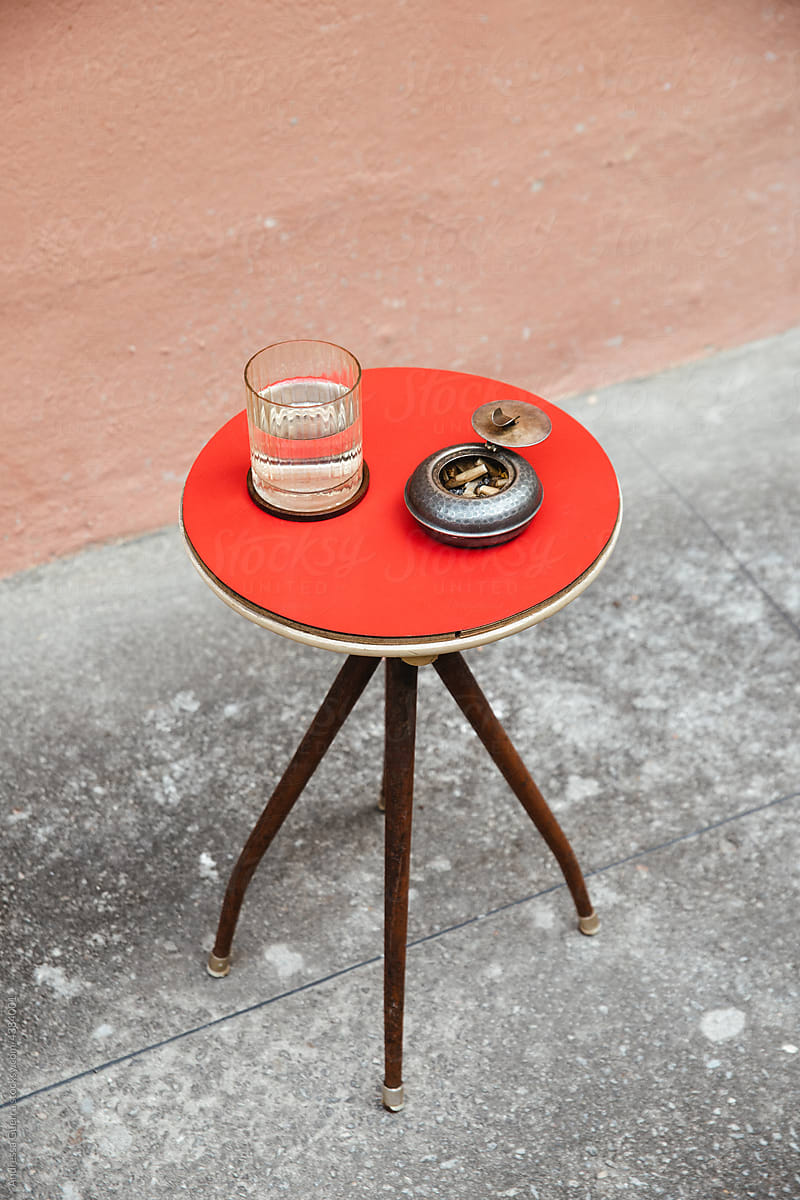 Red round stool set up in front of a salmon wall