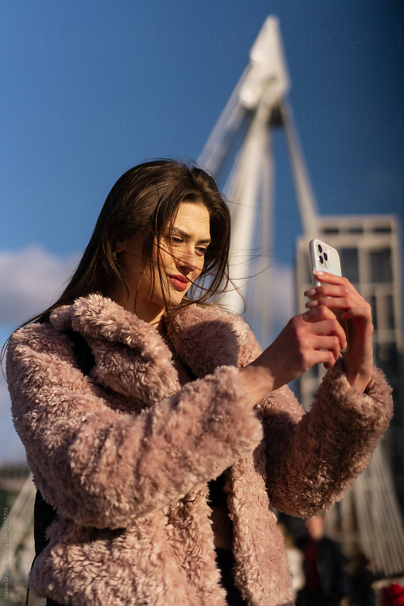 A woman uses her smartphone to take photos outdoor