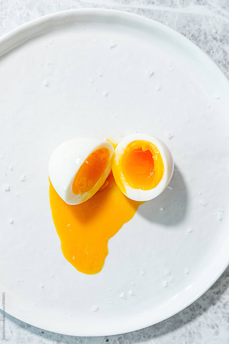 Runny soft boiled egg on white plate