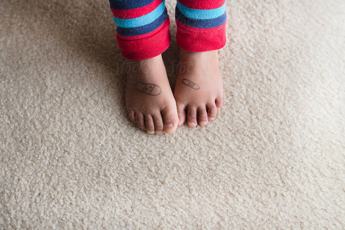 Child with bandage drawn on bare feet