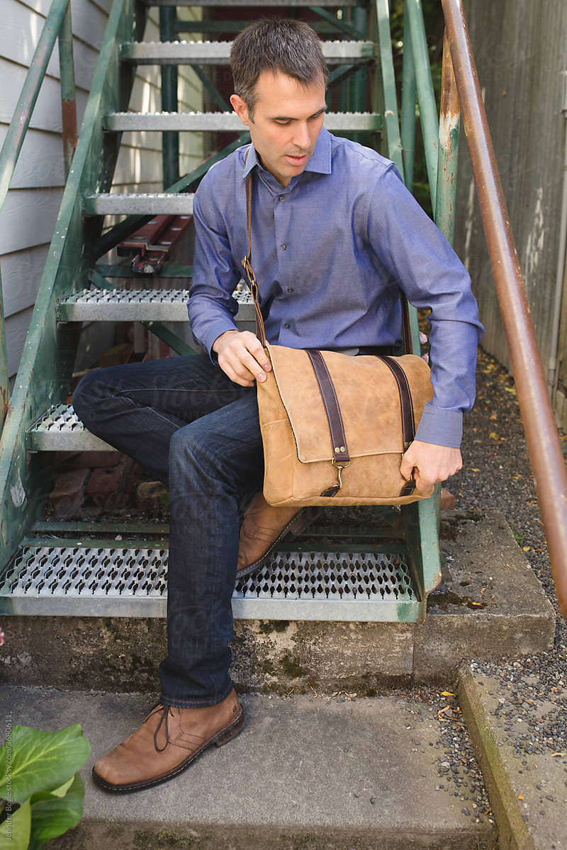 Man on steps with leather messenger bag