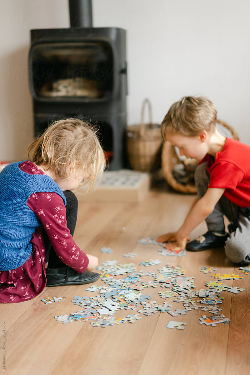 boy and girl, siblings solving a jigsaw puzzle