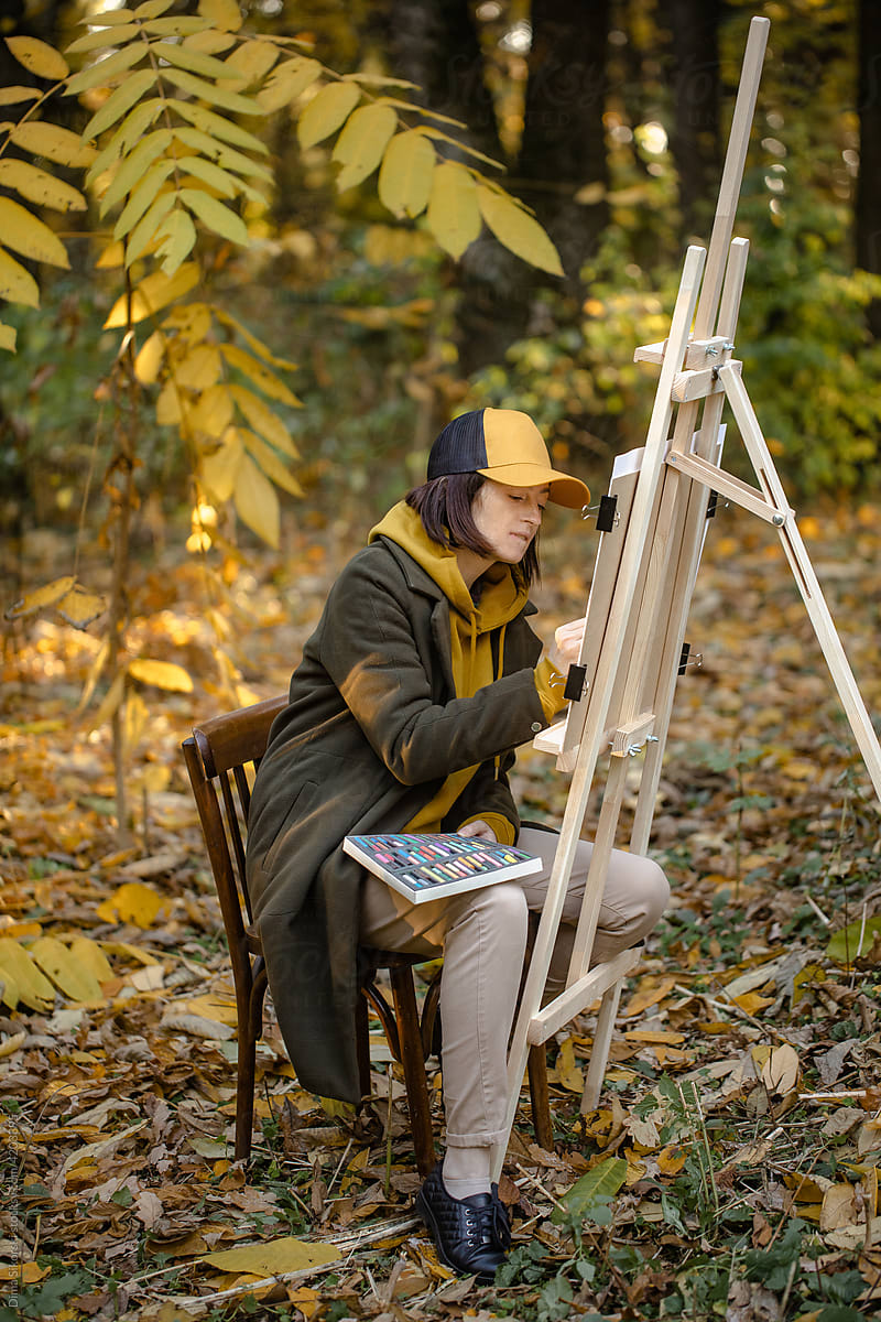 A woman paints in autumn