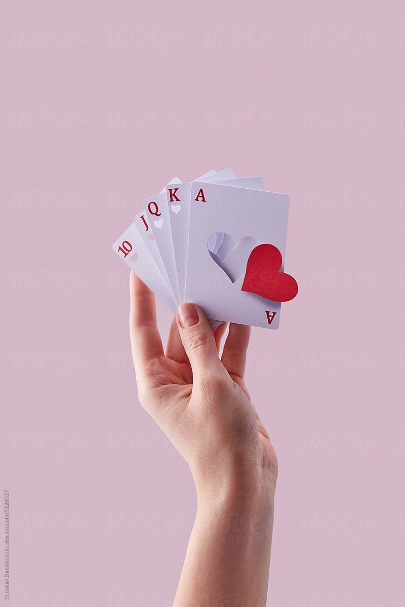 Cards with cut red falling paper heart in hand.