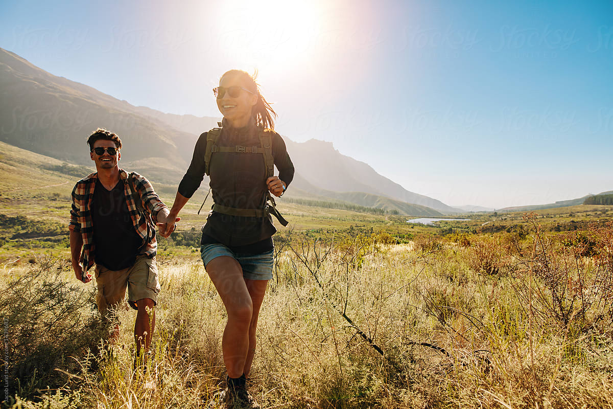 Happy Young Couple Hiking Together On A Summer Day By Jacob Lund Stocksy United