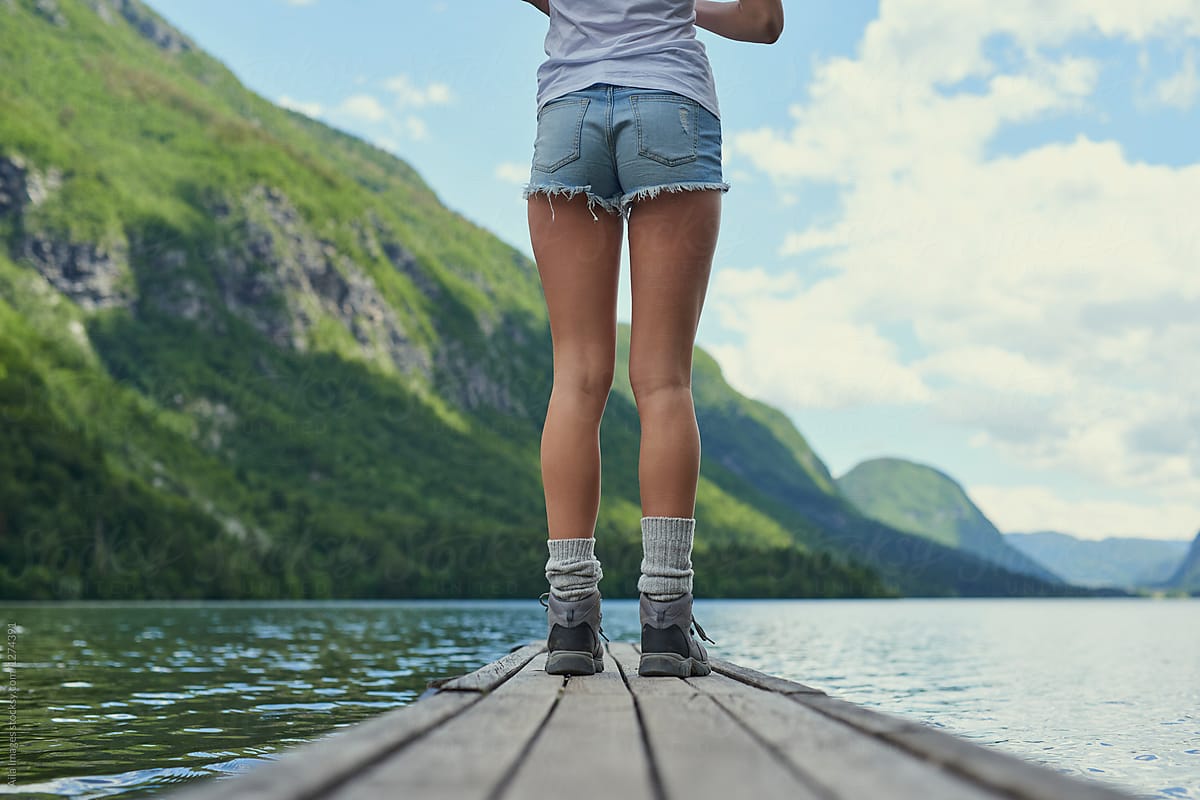 Travel adventure hiker woman on lake jetty enjoying beautiful na