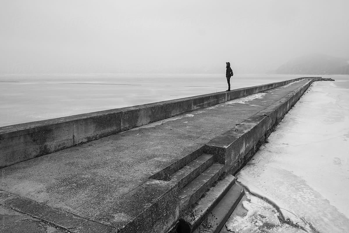 Person Standing Alone On The Dock In The Wintertime