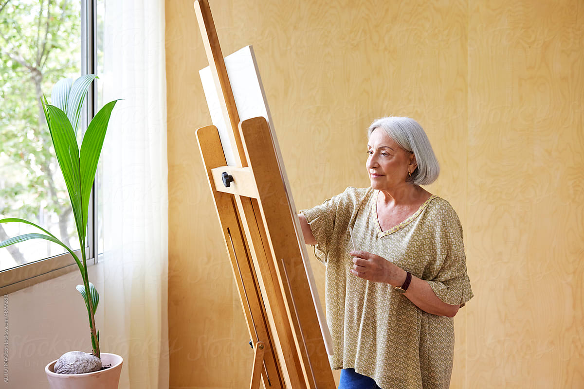 Aged woman drawing at home