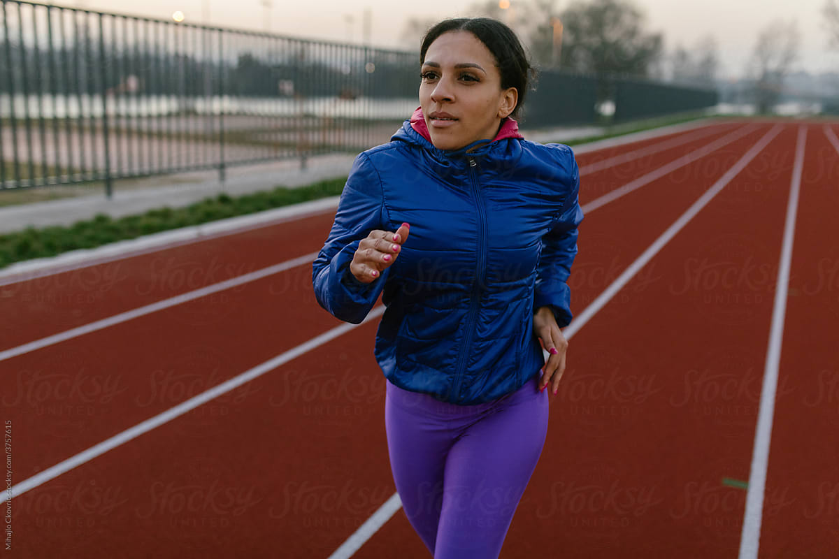 Woman Running On Track Field