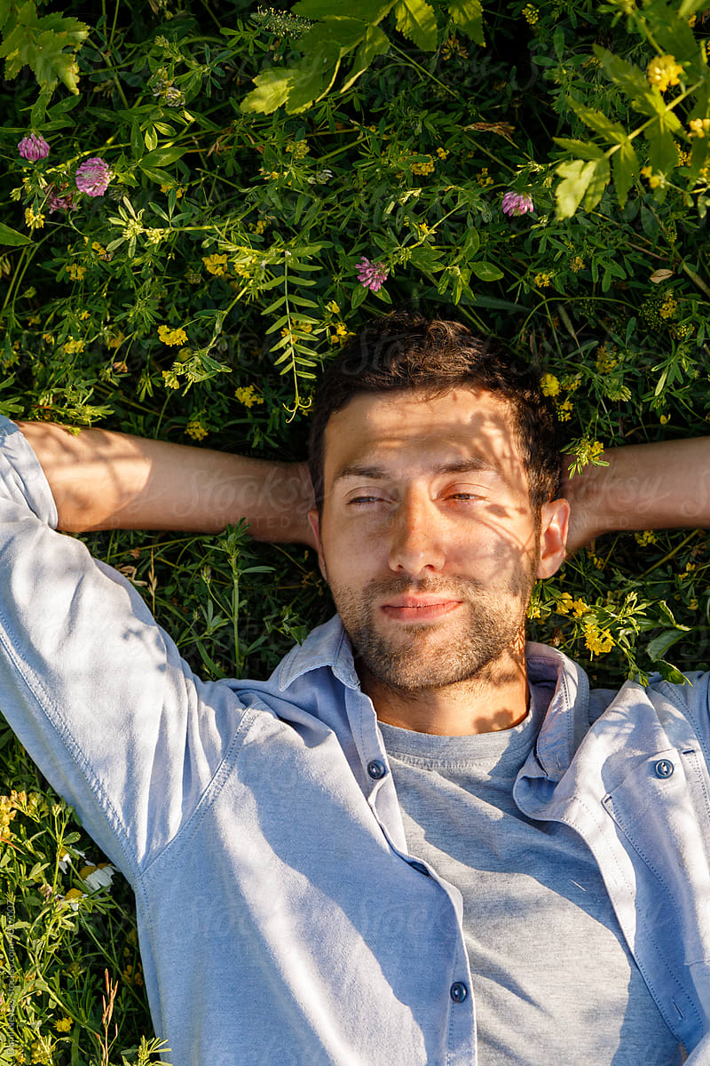 Adult man relaxing on grassy ground
