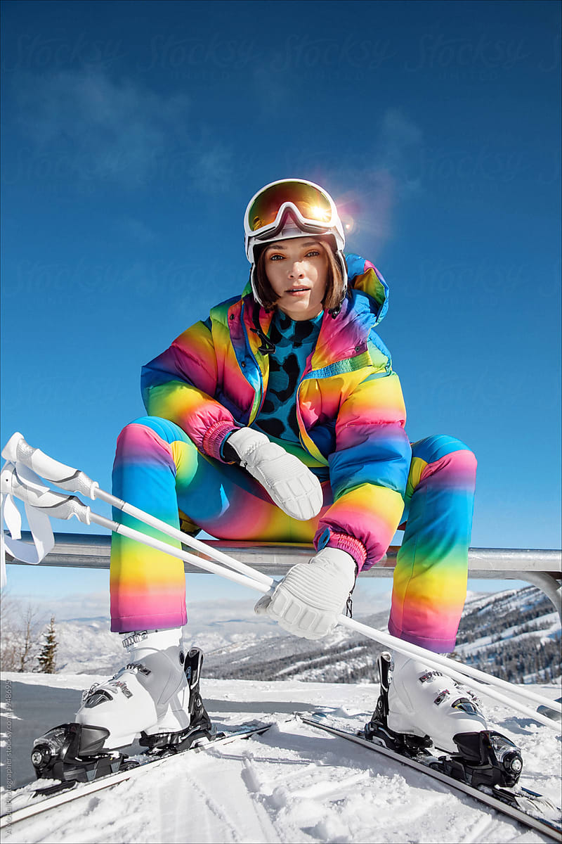 A woman in a fashionable ski outfit skiing in the mountains