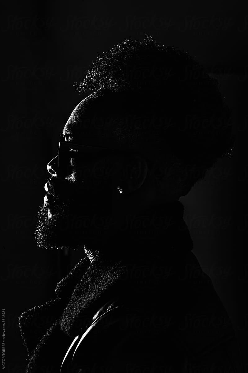Silhouette of black man against black background