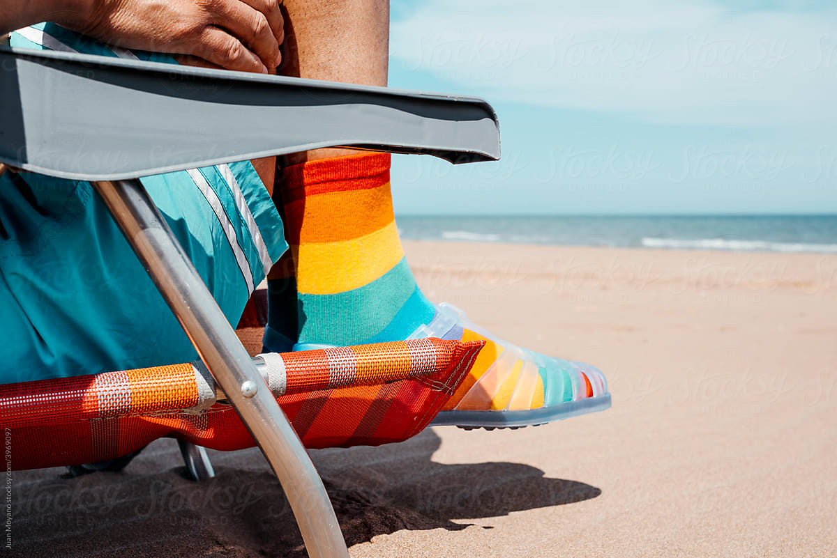 man wearing rainbow patterned socks and sandals