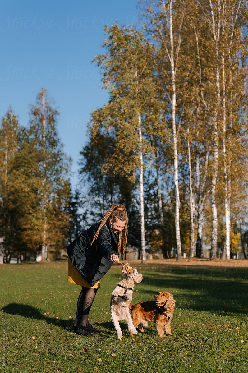 Female owner playing with dog in autumn