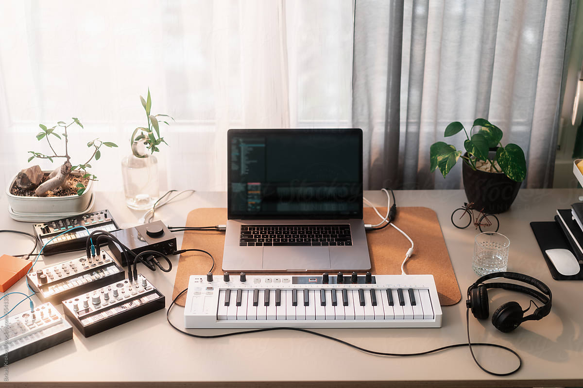 Desk With Music Instruments, Synthesizers And A Laptop Computer