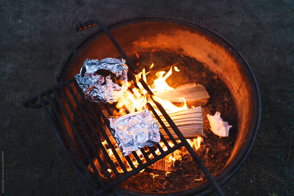 Tin Foil meals roasting over an open flame at a campsite