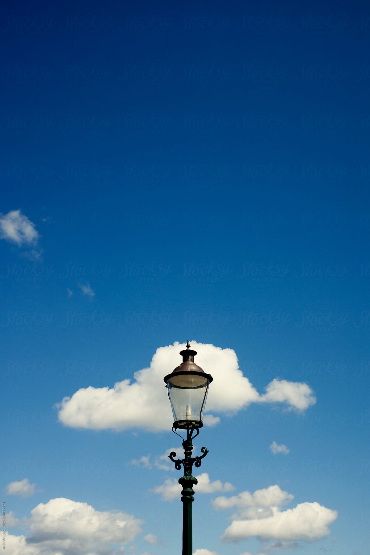 A classic lantern with a bright blue sky with some clouds
