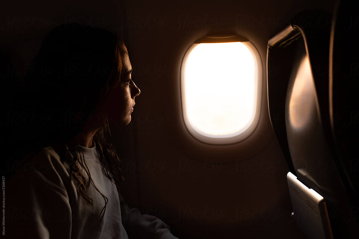 Pre-teen looks out a plane window