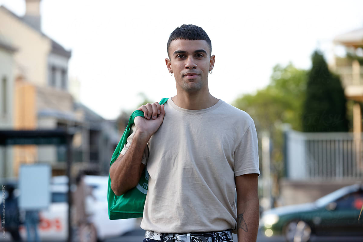 Young Indigenous Australian man holding reusable shopping bag