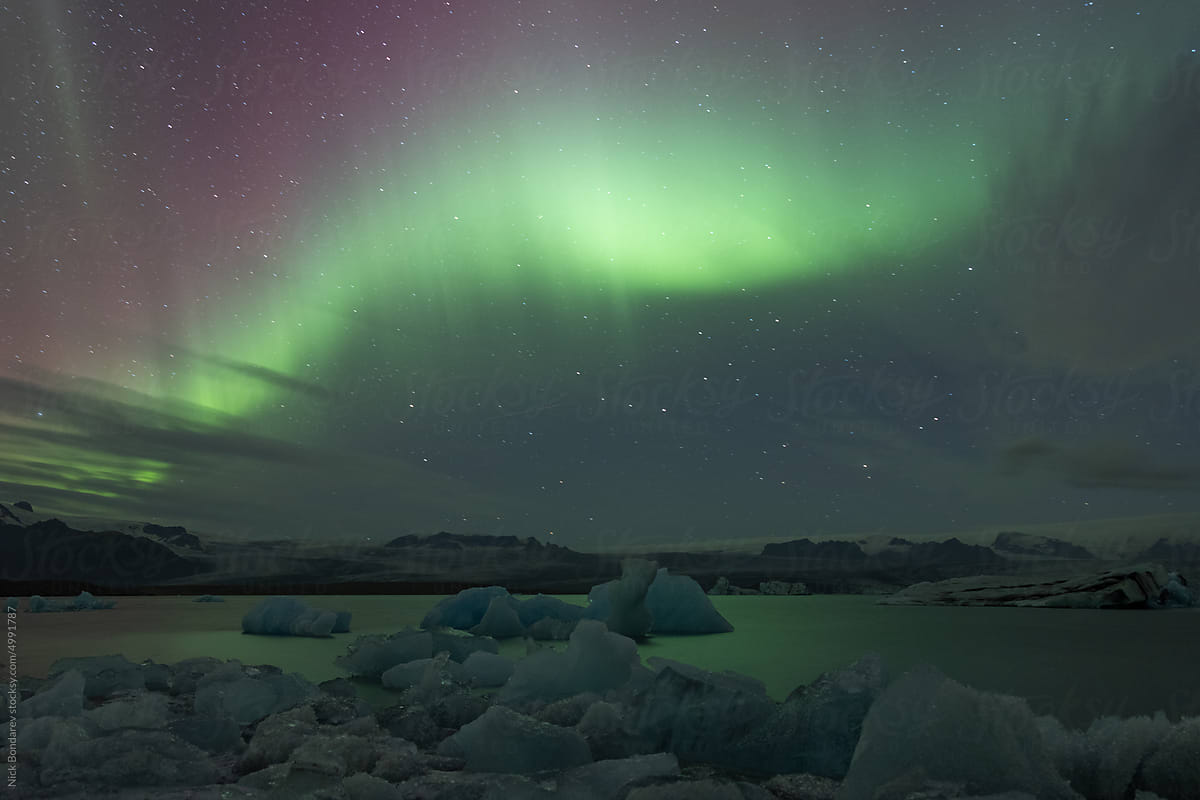 Lake with ice against sky with aurora